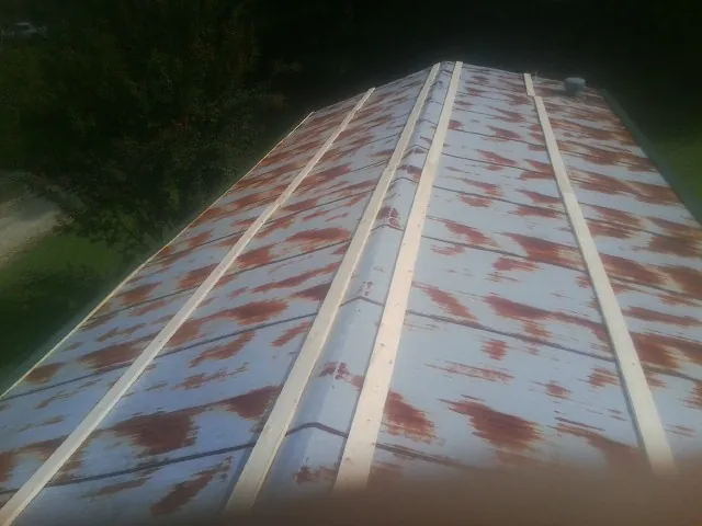 Rusted metal roof panels with new wood purlins before replacement — Storm Damage Roof Repair in North Tonawanda by Roofing Brothers