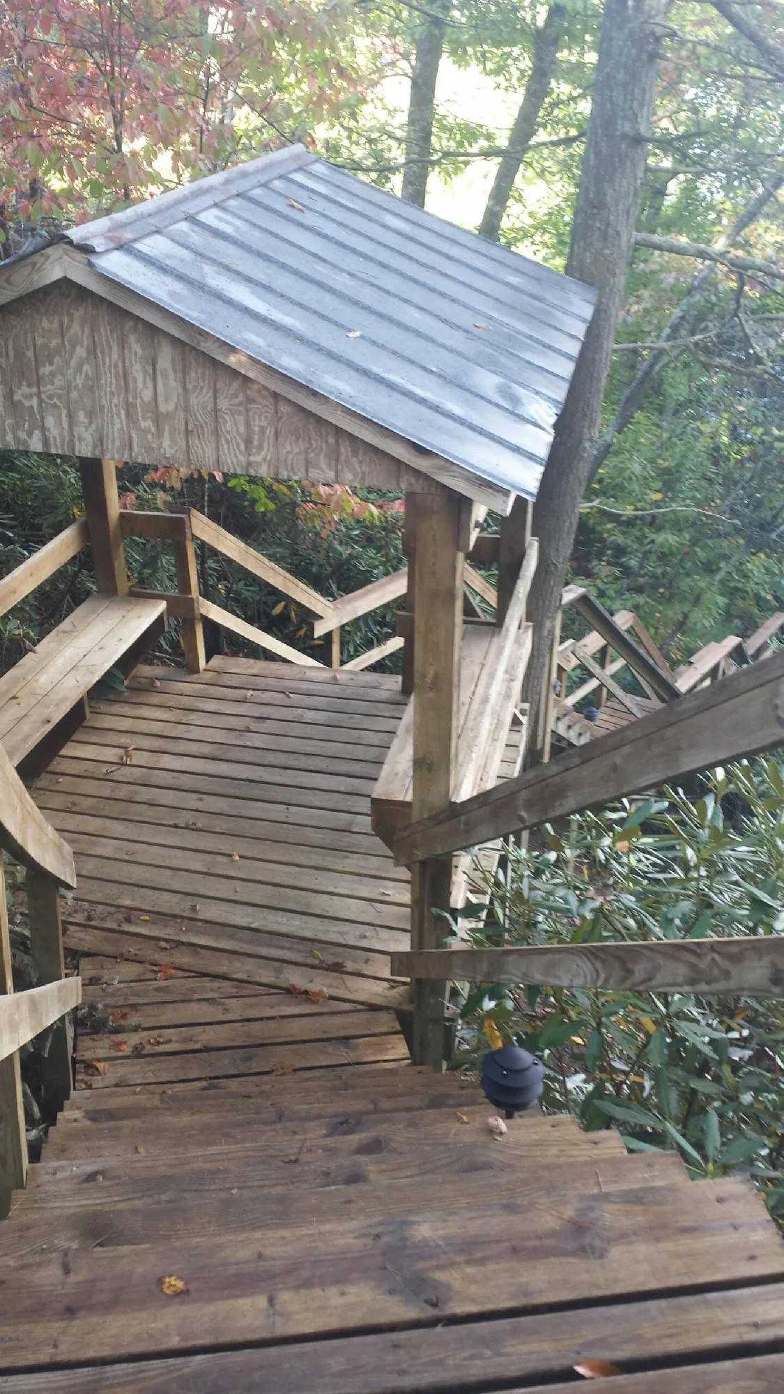 Metal roofed shelter over wooden steps on a wooded walkway — Skylight Repair & Installation work by our crew in North Tonawanda
