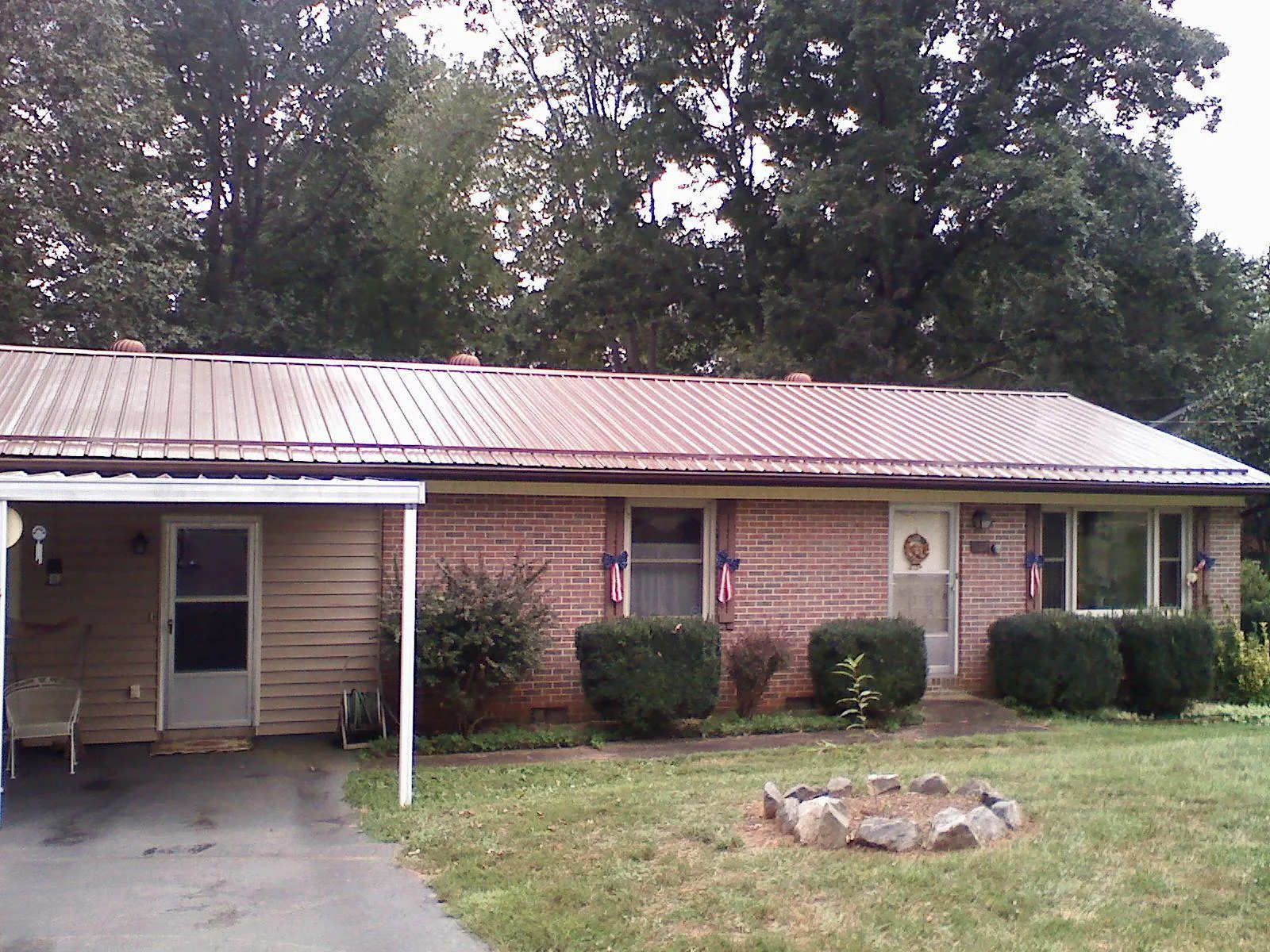 Bronze metal roof and carport on a brick ranch home — Roof Repair work by our crew in North Tonawanda
